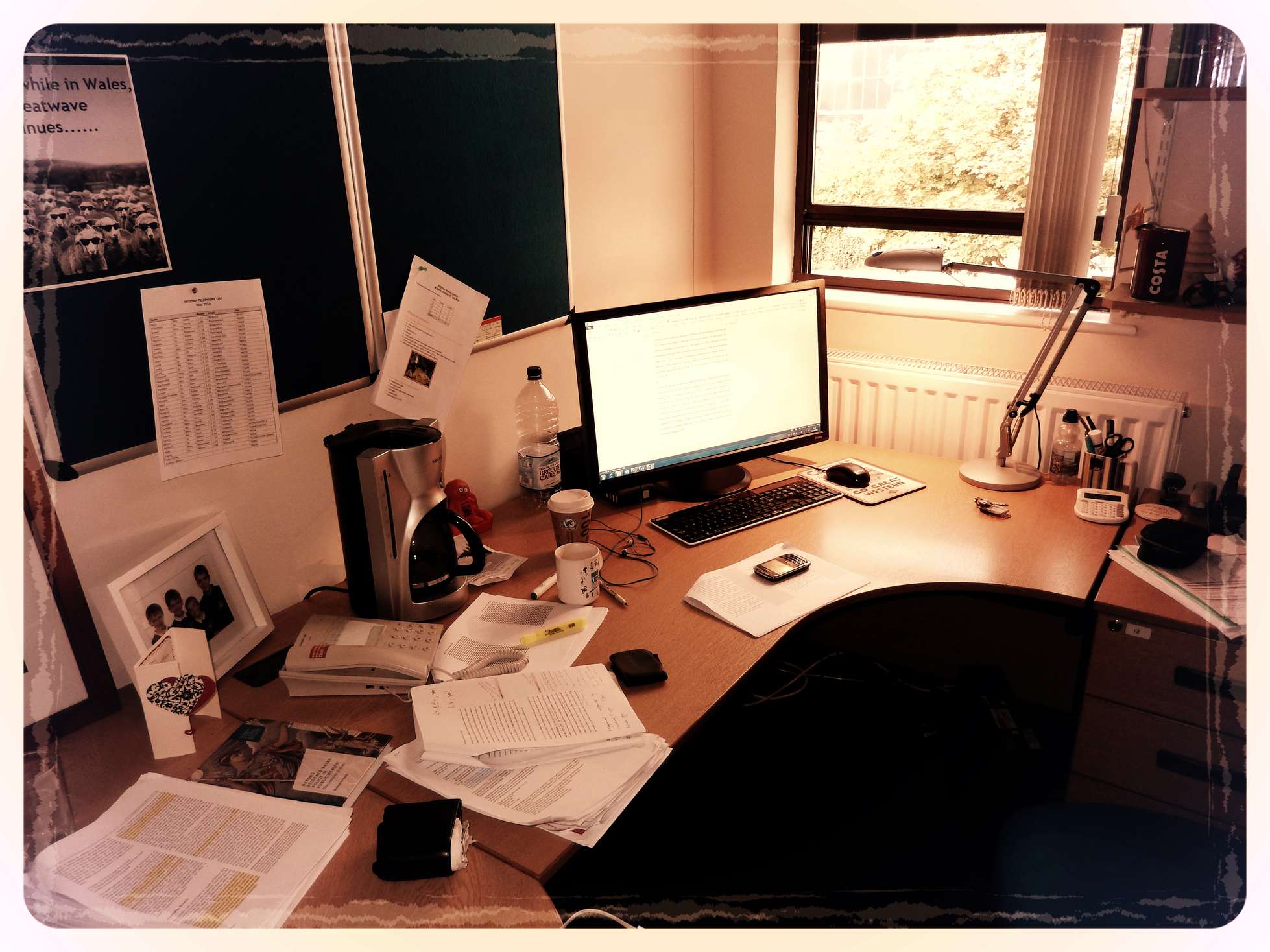 Schreibtisch mit Computer, Tastatur und Arbeitsmaterialien in einem Büro